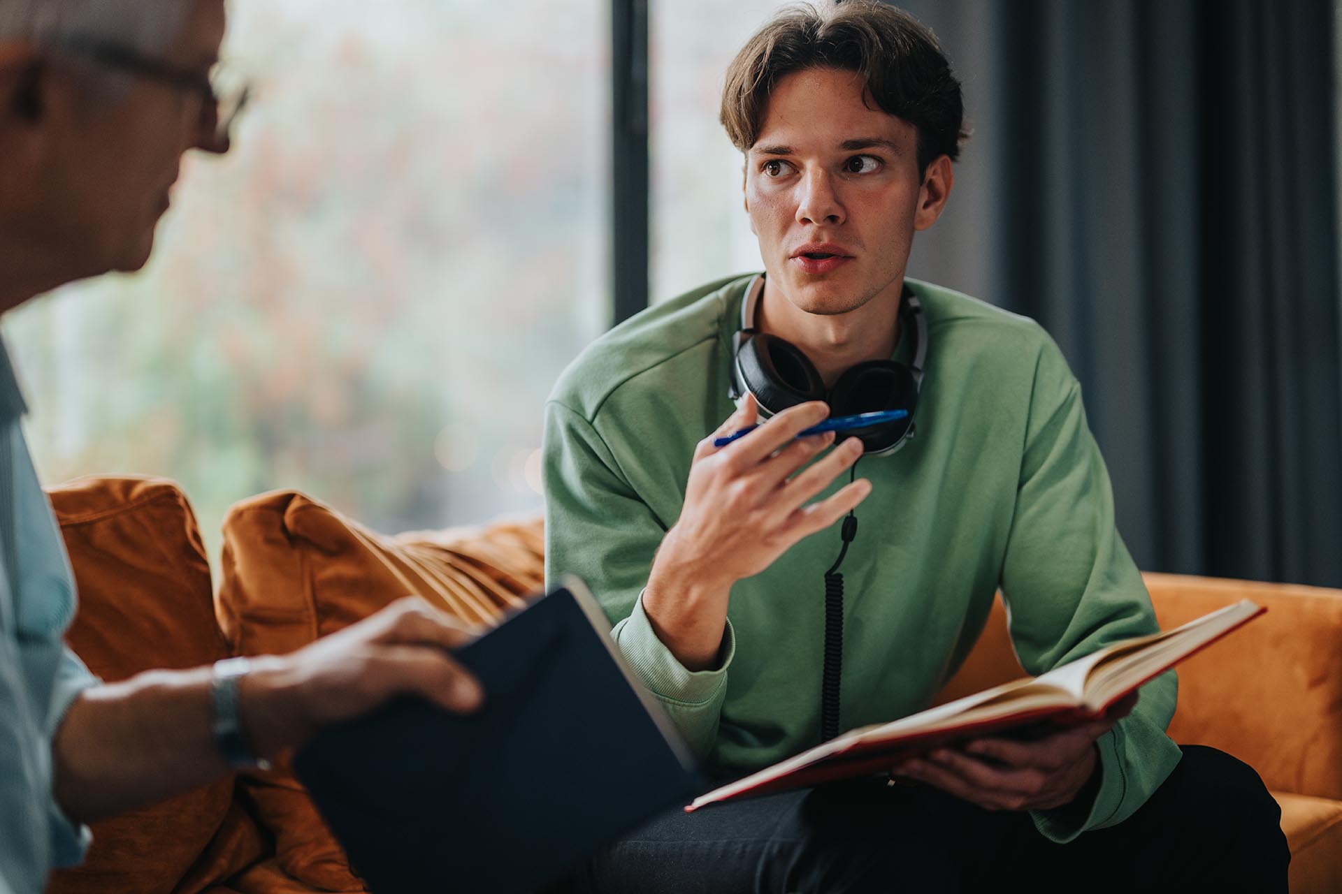 Young man discussing ideas with an older mentor at home